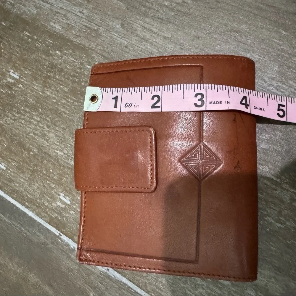 Vintage Brown Leather Wallet with Snap Closure and Embossed Emblem